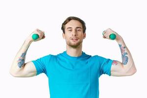 sportief Mens met gemotiveerd omhoog armen halters training tatoeëren bijgesneden visie foto