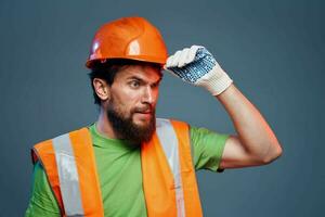 gebaard Mens in oranje moeilijk hoed handschoenen professioneel bijgesneden visie blauw achtergrond foto