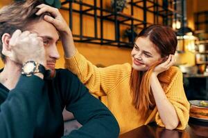 gelukkig vrouw in een trui gebaren met haar handen pret emoties en een Mens in een trui zit in een cafe foto