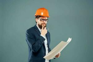 mannetje ingenieur met blauwdrukken in de handen van een oranje moeilijk hoed industrie professioneel foto