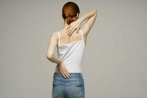 vrouw in wit t-shirt chiropractie reuma Gezondheid problemen licht achtergrond foto