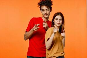 vent en meisje in kleurrijk t-shirts pret studio oranje achtergrond foto