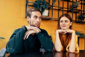 Mens en vrouw zijn zittend in een cafe Bij de tafel en gebaren met hun handen vrienden emoties pret interieur foto