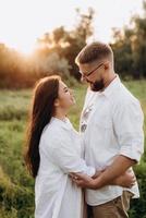 jong stel verliefd op een man met een baard en een meisje met donker haar in lichte kleren foto