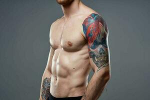 Mens met gemotiveerd omhoog druk op tatoeëren Aan zijn armen bijgesneden visie studio foto
