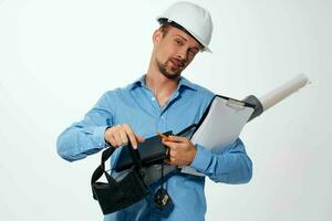 een Mens in een blauw overhemd in een bouw helm blauwdrukken voor bouw professionals foto