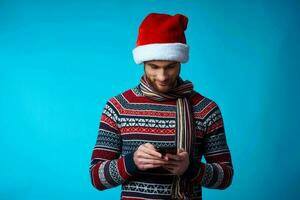 vrolijk Mens met een telefoon in hand- vakantie Kerstmis technologie blauw achtergrond foto