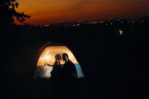 jong stel een jongen en een meisje met fleurige gebreide mutsen stopten op een camping foto