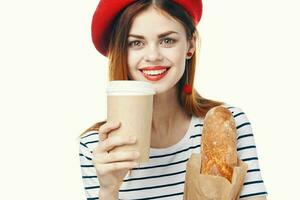 vrolijk vrouw met Frans brood en een kop van heet drinken fijnproever levensstijl foto