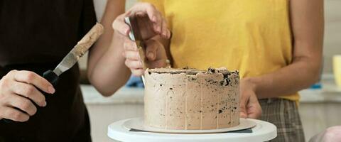 Dames paar maken chocola taart in keuken, detailopname. taart maken werkwijze, selectief focus, banier formaat foto