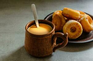 de meest heerlijk eigengemaakt donuts en koffie met melk in een volk mok. huis Koken. foto