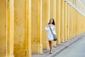 mooi vrouw wandelen in de omgeving van de omringt door een muur stad in Cartagena de india's foto