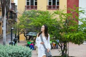 mooi vrouw Aan wit jurk wandelen alleen Bij de muren omgeving van de koloniaal stad van Cartagena de india's foto