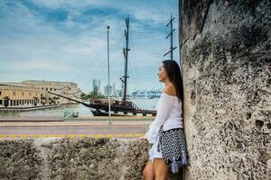 mooi vrouw staand Bij de muren van Cartagena de india's op zoek naar de baai foto