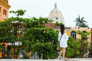 mooi vrouw Aan wit jurk wandelen alleen Bij de muren omgeving de koloniaal stad van Cartagena de india's foto