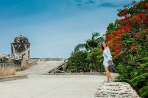 mooi vrouw Aan wit jurk wandelen alleen Bij de muren omgeving de koloniaal stad van Cartagena de india's foto