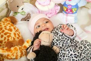 vier maanden baby meisje omringd door gevuld dieren foto