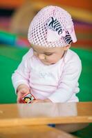 portret van een mooi negen maanden baby spelen Aan een kleurrijk achtergrond. aan het leren concept foto