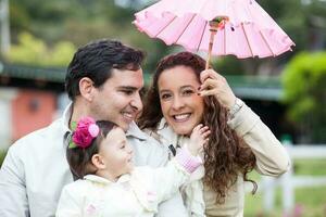 jong ouders hebben pret buitenshuis met hun een jaar oud baby meisje. geluk concept. familie concept foto