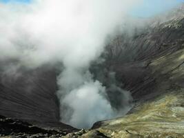 dichtbij omhoog van vulkaan krater spuwen rook Bij monteren bromo foto