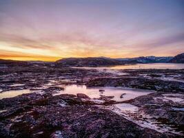 magenta winter ochtendgloren. de ijzig landschap en bergen in de Russisch dorp teriberka foto