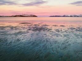 luxe patronen van water Aan de arctisch kust van de barentsz zee. verbazingwekkend zonsondergang in de noorden van de kola schiereiland foto