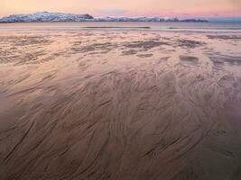 de structuur van de zand Aan de zee strand Bij laag tij Bij zonsondergang. foto