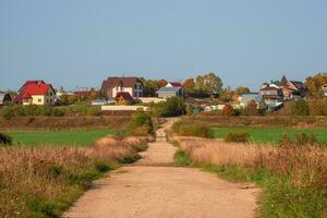 een leeg aarde land weg naar een heuvel met huisjes. foto