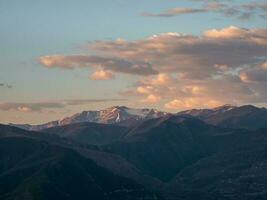 Kaukasus bergen Bij ochtendgloren. sfeervol landschap met silhouetten van bergen Aan achtergrond van roze dageraad lucht. kleurrijk natuur landschap met zonsondergang of zonsopkomst. zonsondergang in vervaagd tonen. foto