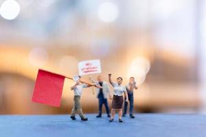 miniatuurmensen, demonstranten die borden vasthouden, hun hand opsteken voor revolutie foto