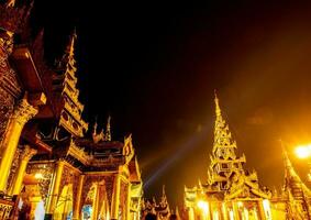 de gouden pagodes en mondops zijn verlichte in de licht van de nacht foto