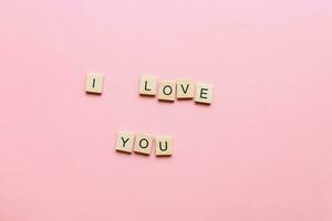 ik liefde u gemaakt van houten brieven Aan een roze achtergrond. ronduit ik liefde jij. belettering ik liefde u foto