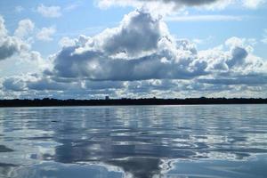 stapelwolken weerspiegeld in de zee foto