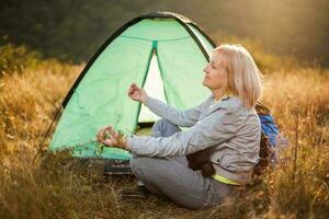 een senior vrouw camping foto