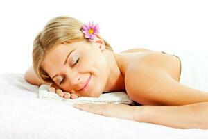 jong vrouw ontspannende na massage Aan spa behandeling foto