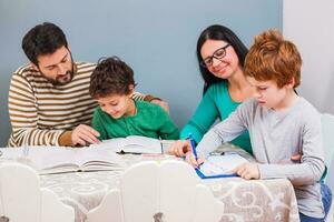 ouders helpen hun kinderen met hun huiswerk foto