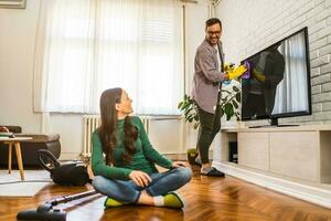 jong paar is schoonmaak hun appartement foto