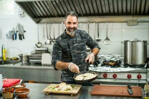 een chef is voorbereidingen treffen een maaltijd in de restaurants keuken. foto