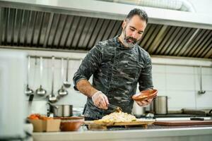 een chef is voorbereidingen treffen een maaltijd in de restaurants keuken. foto