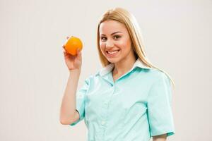 een verpleegster Holding een fruit in haar hand- foto