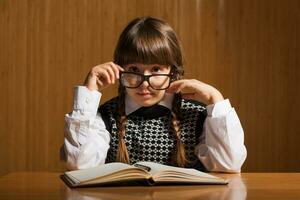 een weinig meisje lezing een boek foto