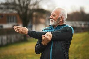 een senior Mens aan het doen fysiek opdrachten foto