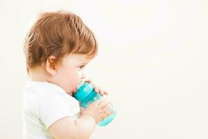 een klein kind drinken water foto