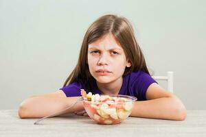 een meisje aan het eten een fruit salade foto