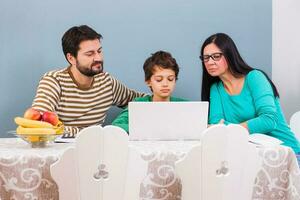 ouders zijn onderwijs hun zoon naar gebruik de laptop foto