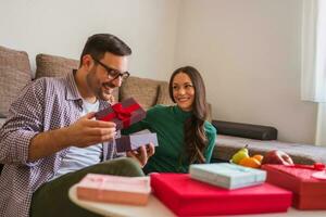 paar uitwisselen cadeaus in hun huis foto