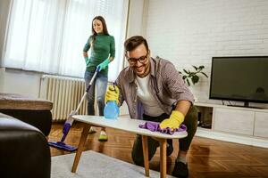 jong paar is uitgeput van schoonmaak hun appartement foto