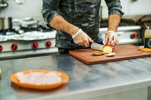 een chef is voorbereidingen treffen een maaltijd in de restaurants keuken. foto