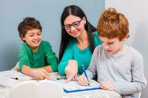 een moeder helpen haar kinderen met de huiswerk foto