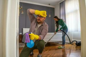 jong paar is schoonmaak hun appartement foto